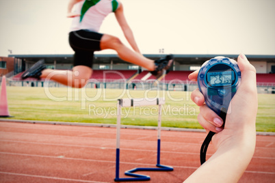 Composite image of a woman holding a chronometer to measure perf