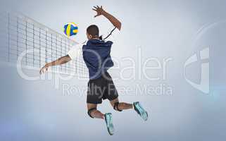 Rear view of sportsman hitting volleyball