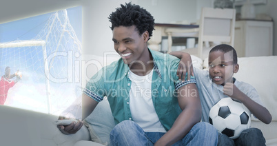Composite image of father and son are watching sport on televisi