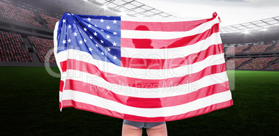 Composite image of athlete posing with american flag after victo