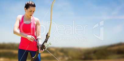 Composite image of athletic woman practicing archery