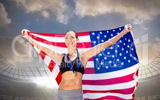 Composite image of happy sportswoman posing with an american fla