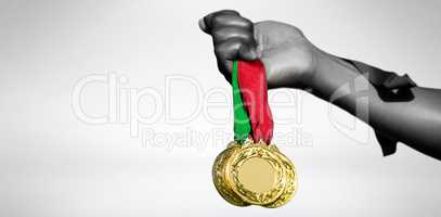 View of hand holding three gold medals