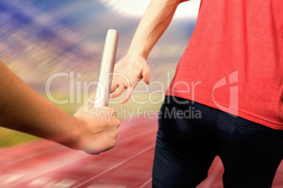 Composite image of athlete passing a baton to the partner