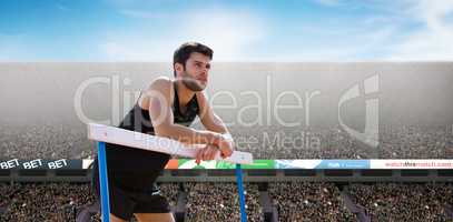 Composite image of athletic man pressed on a hurdle posing