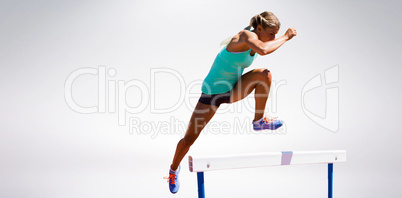 Athlete woman jumping a hurdle