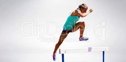 Athlete woman jumping a hurdle