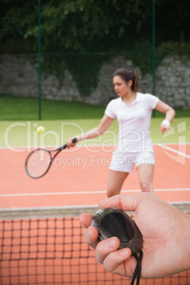 Composite image of close up of coach is holding a stopwatch