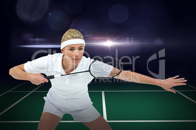 Composite image of female athlete holding a badminton racket rea