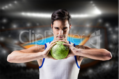 Composite image of portrait of happy athlete man holding ball