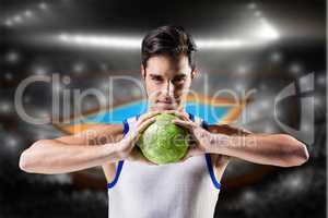 Composite image of portrait of happy athlete man holding ball