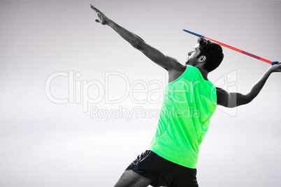 Composite image of profile view of sportsman practising javelin