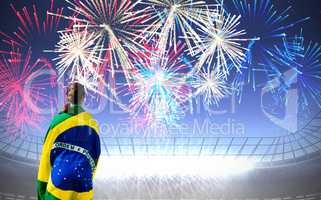 sporty woman holding the Brazilian flag against fireworks explod