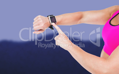 Composite image of female athlete using her smart watch