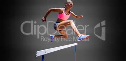 Sporty woman jumping a hurdle