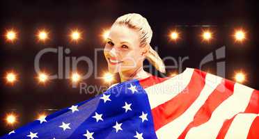 Composite image of sporty girl holding an american flag