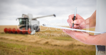 Composite image of delivery man writing on clipboard