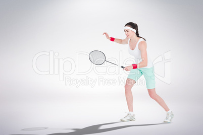 Composite image of female athlete playing badminton