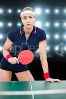 Composite image of female athlete leaning on ping pong table