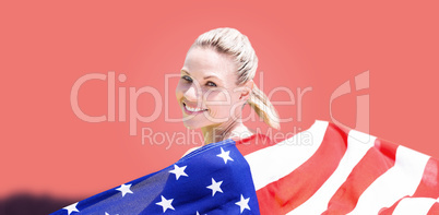 Composite image of sporty girl holding an american flag