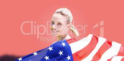 Composite image of sporty girl holding an american flag