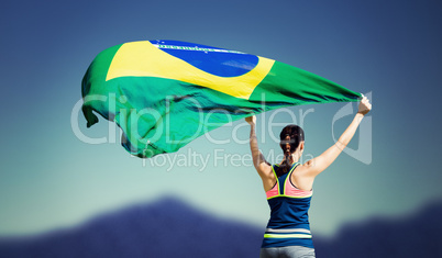 Rear view of sportswoman raising a brazilian flag