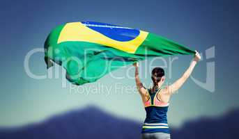 Rear view of sportswoman raising a brazilian flag