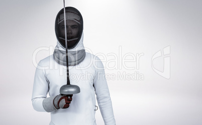 Composite image of man wearing fencing suit practicing with swor