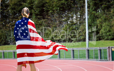 Composite image of rear view of sporty woman holding an american