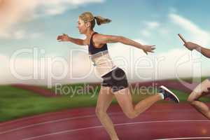 Composite image of athlete passing a baton to the partner