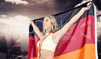 Composite image of athlete posing with german flag after victory