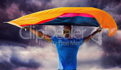 Composite image of sporty man holding a german flag