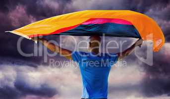 Composite image of sporty man holding a german flag