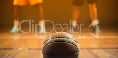 Close up on basketball putting on the floor in front of basketba