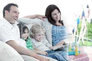 Composite image of happy family watching television together