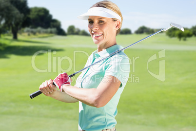 Composite image of woman golf player looking the camera