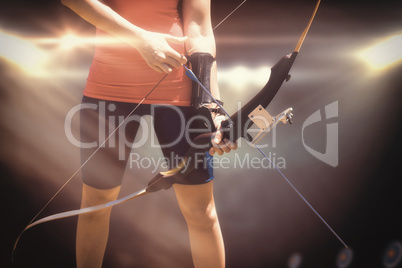 Composite image of focus on sportswoman holding an arch