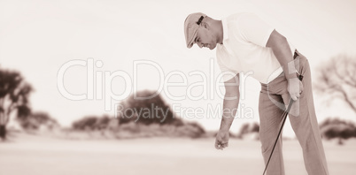 Composite image of golf player picking up golf ball