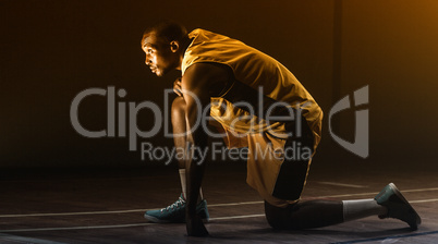 Basketball player preparing to play with knee on the floor and l