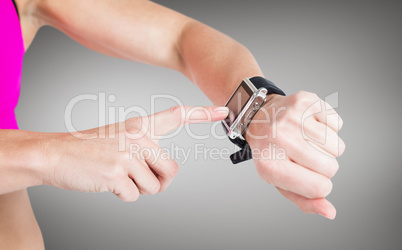 Composite image of female athlete using her smart watch