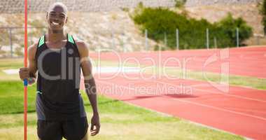 Composite image of front view of happy sportsman is holding a javelin