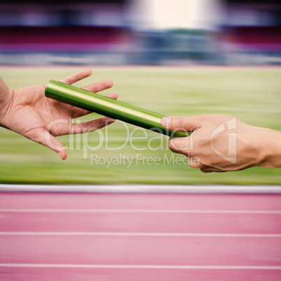 Man passing the baton to partner on track