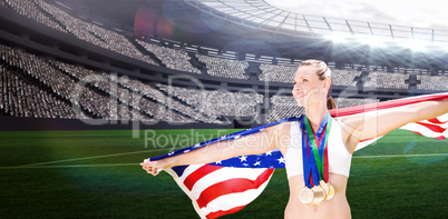 Composite image of portrait of happy sportswoman with medals hol