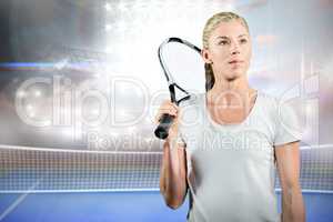 Sportswoman holding a tennis racket and looking away