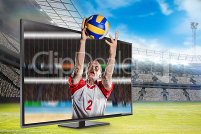 Composite image of sportsman catching a volleyball while playing