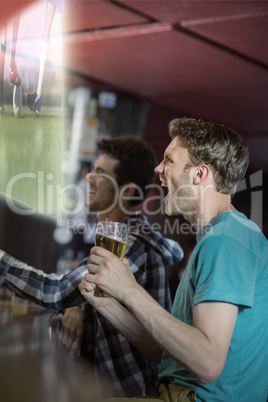 Composite image of friends are watching sport match on televisio