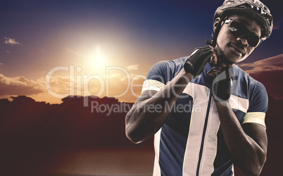 Composite image of athletic man putting his cycling helmet