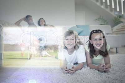Composite image of siblings on the floor watching tv