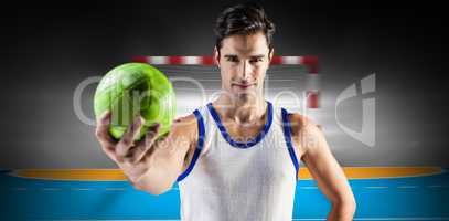 Composite image of portrait of happy male athlete holding a ball