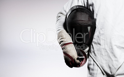 Composite image of mid-section of man standing with fencing mask